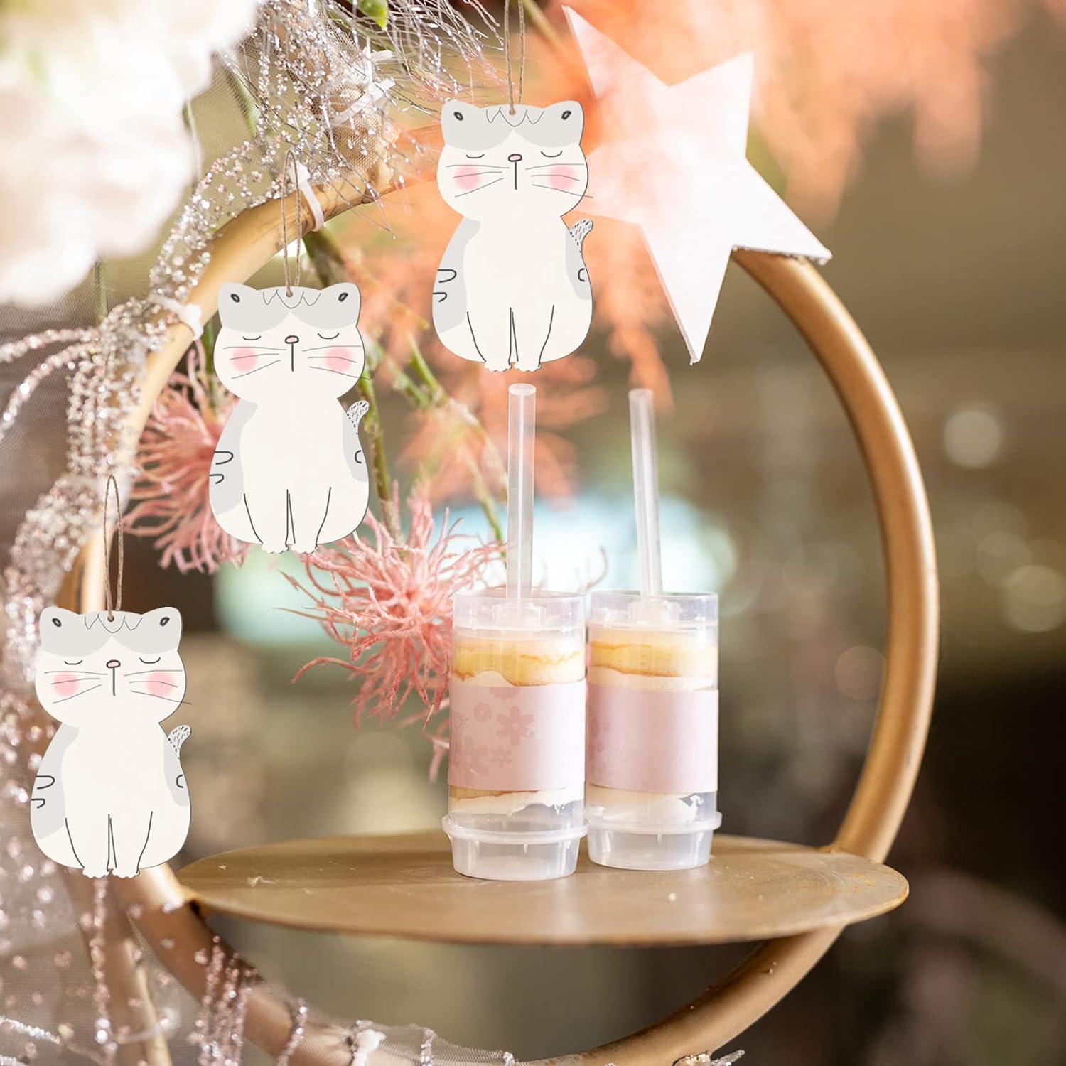 Decorative cat-shaped straws hanging over drinks on a blurred background