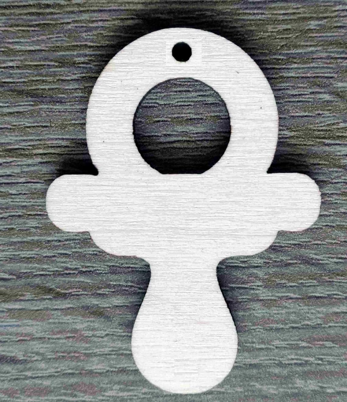 White ankh-shaped pendant on a dark wooden background