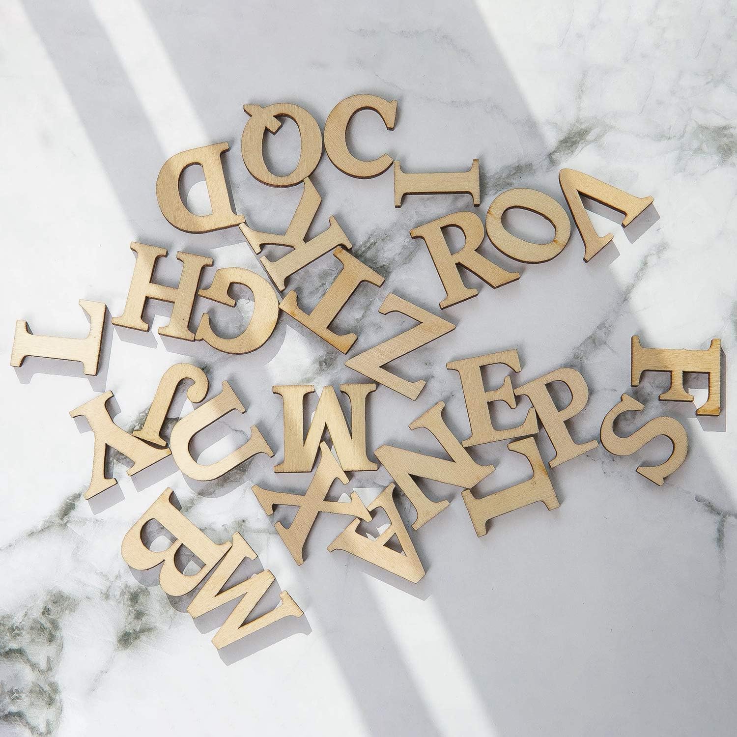 Gold metallic letters scattered on a marble surface