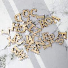Gold metallic letters scattered on a marble surface