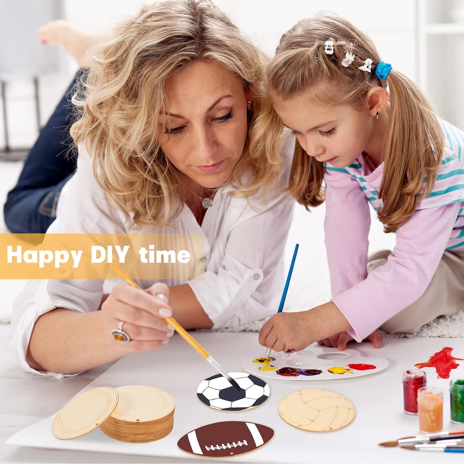 Woman and child engaged in a DIY craft activity with paint and brushes.