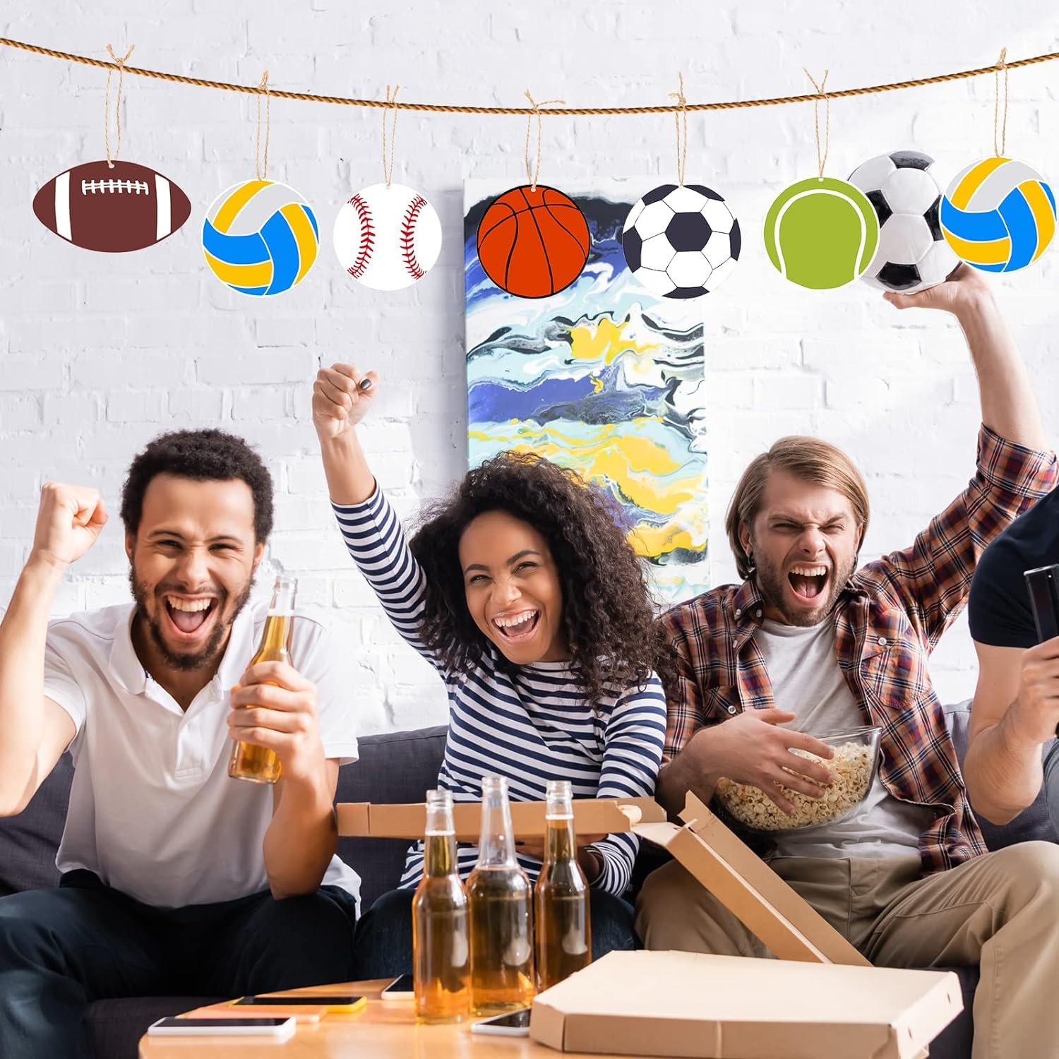 People celebrating with sports-themed decorations and food in a casual setting.