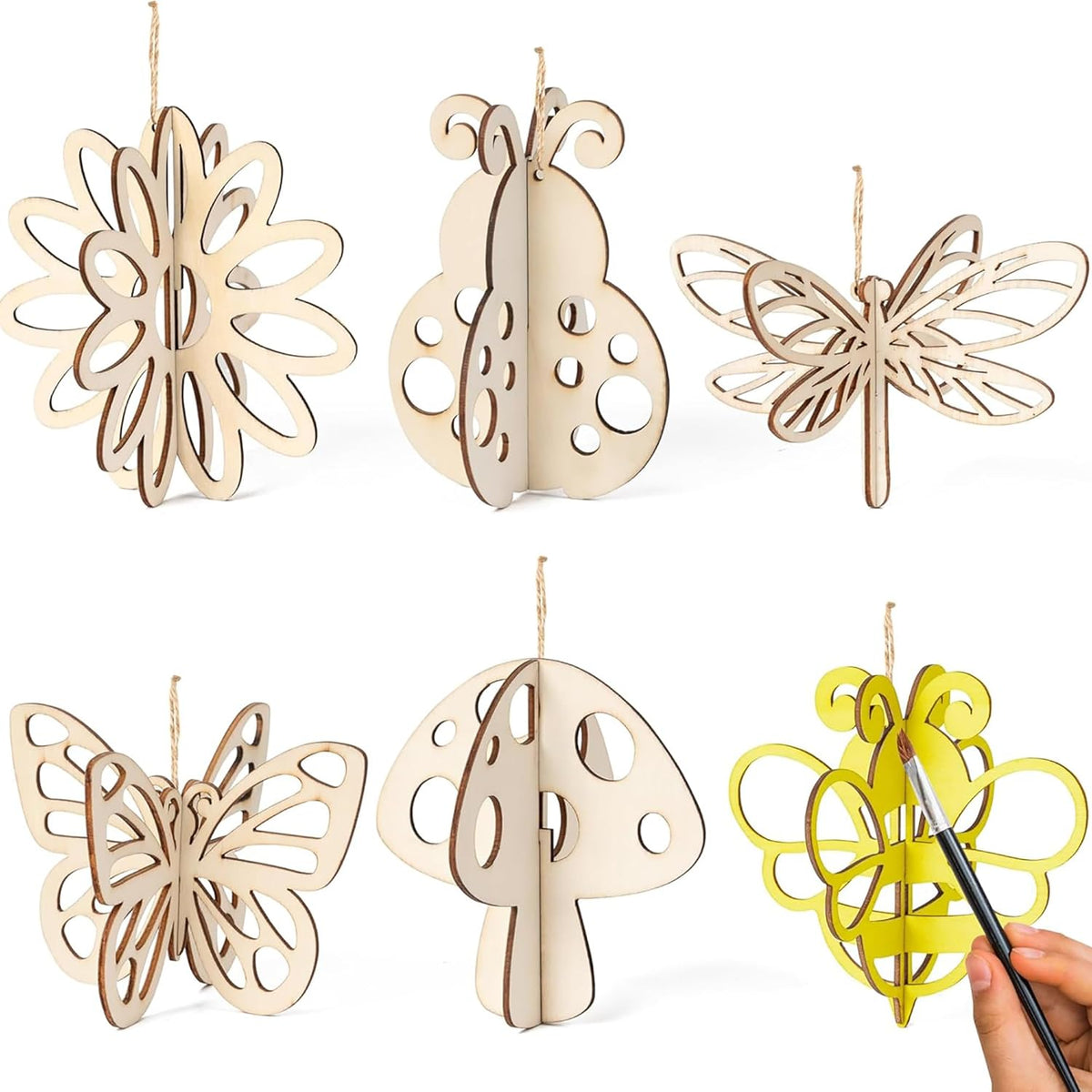 Set of wooden decorative items including butterflies and a mushroom, with a hand holding a paintbrush.