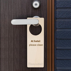 Door handle with a 'Please Clean' sign attached to a hotel room door.