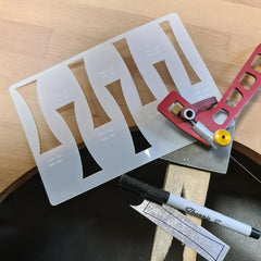 Stencils with letter 'Z' cutouts, a marker, and a small tool on a wooden surface.
