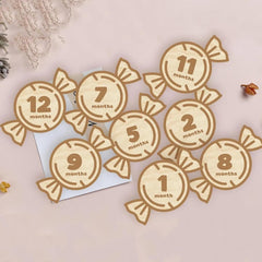 Wooden candy-shaped milestone markers with numbers on a light background