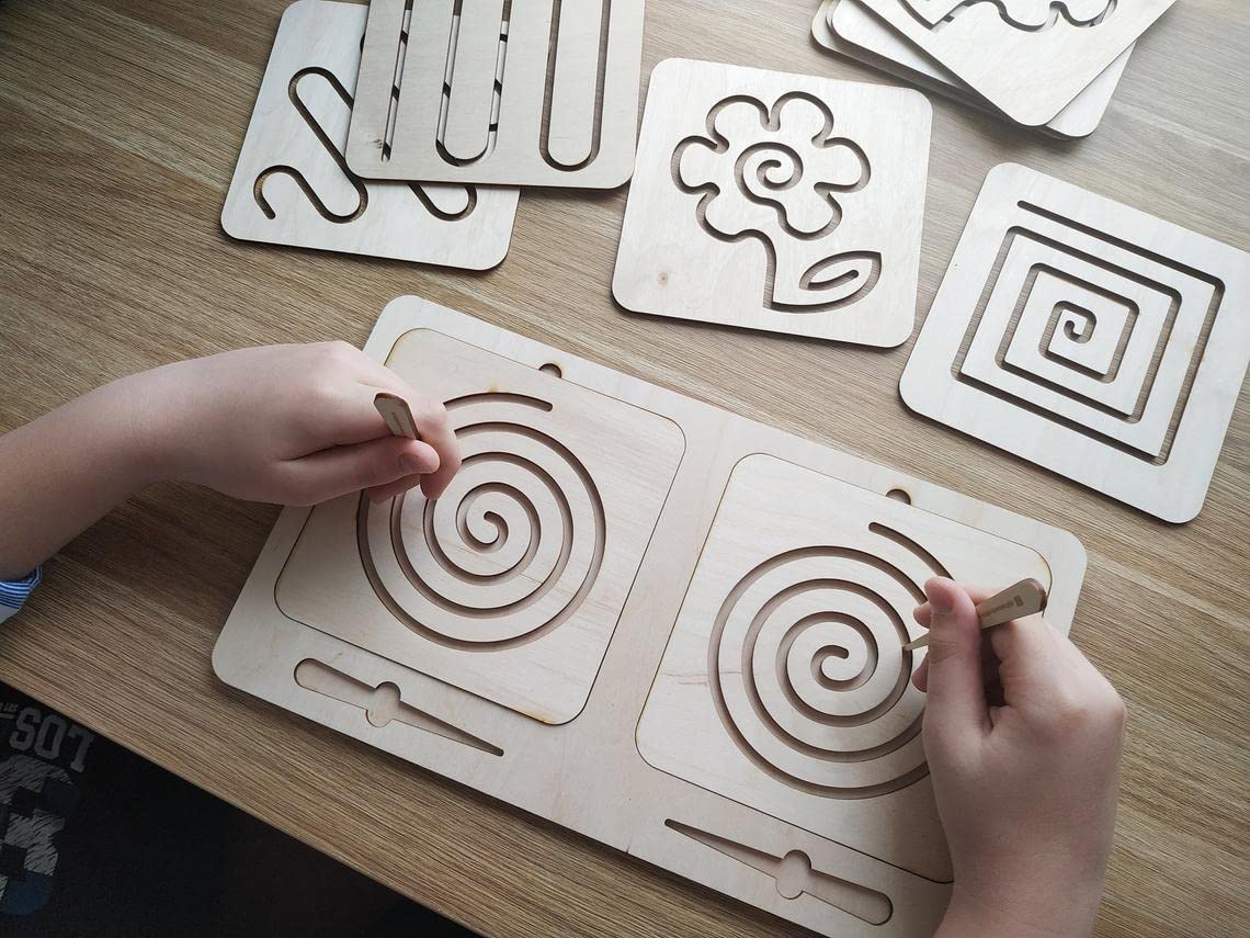 Children's hands interacting with wooden puzzle pieces on a wooden surface