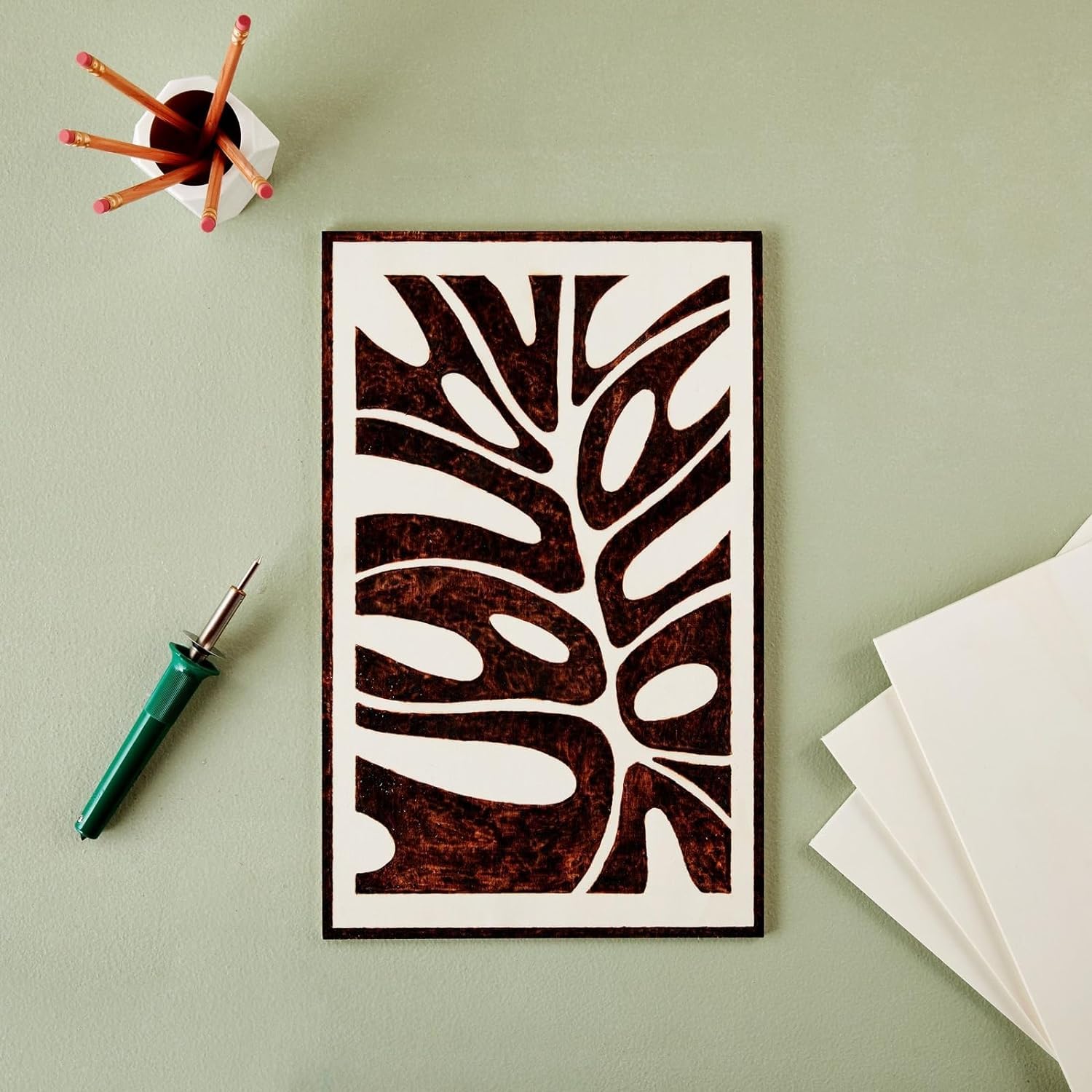 Decorative wall art with tribal design on a light green background