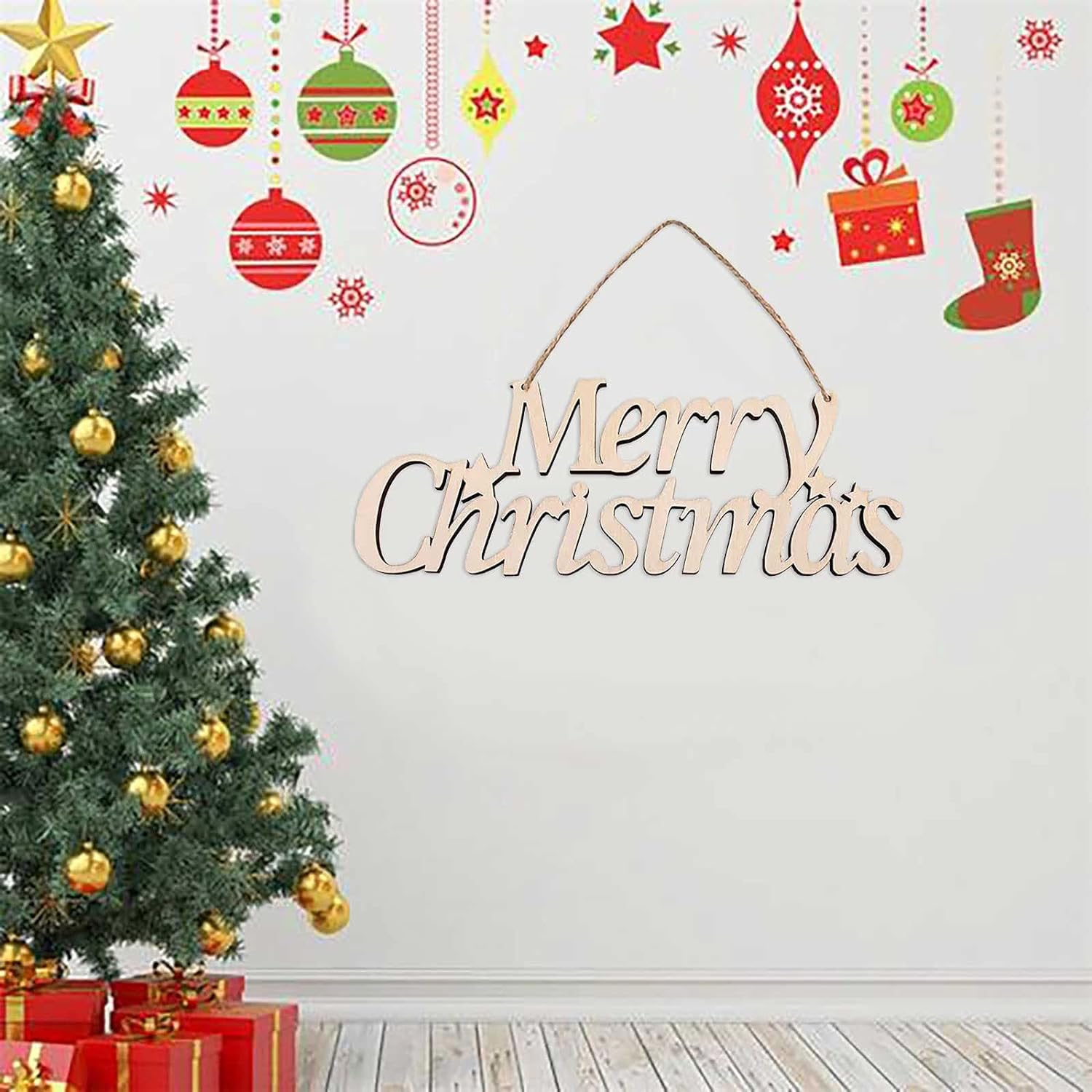 Decorative wall with Christmas tree, ornaments, and 'Merry Christmas' sign on a white wall.