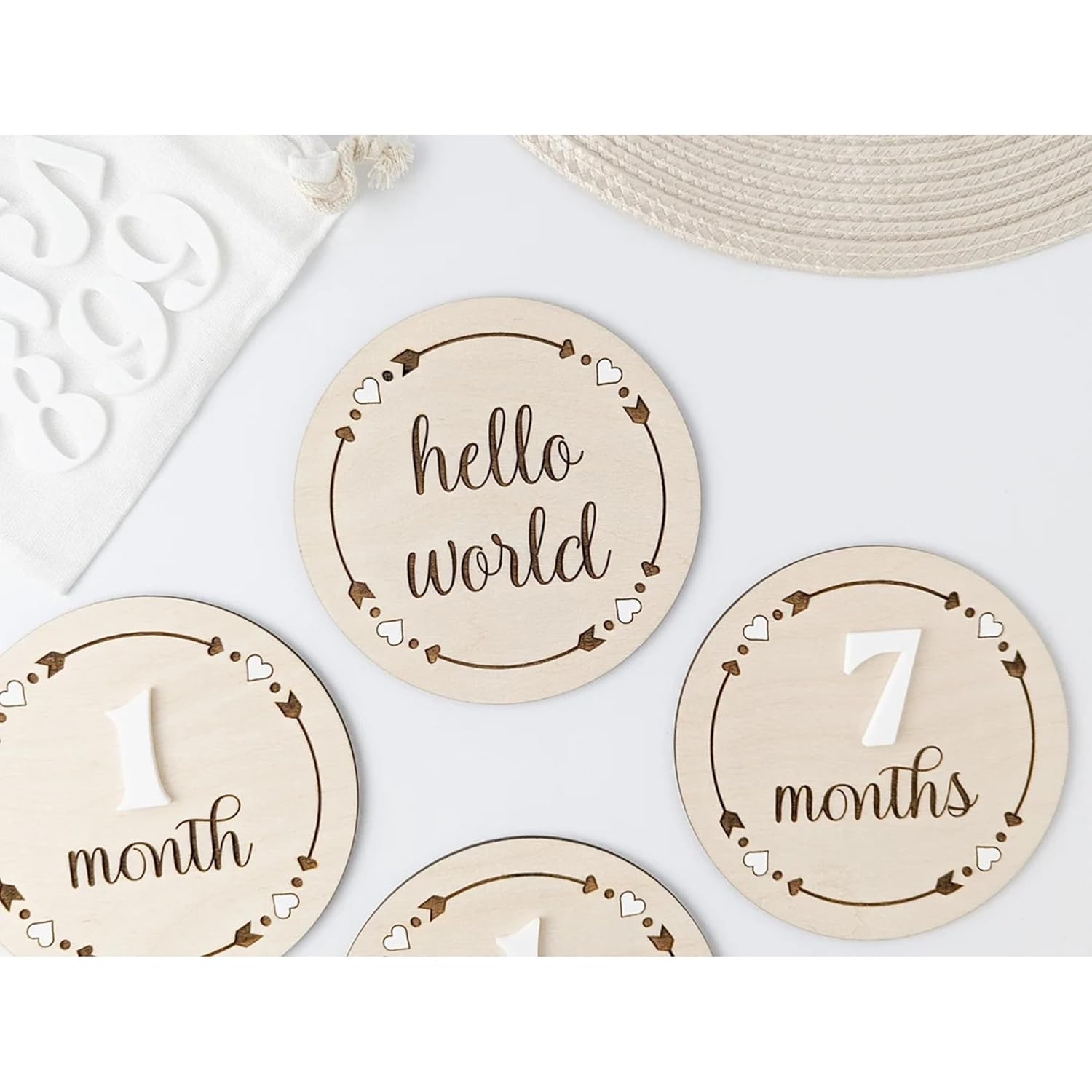 Set of wooden milestone discs with 'hello world' and '7 months' text on a white background.