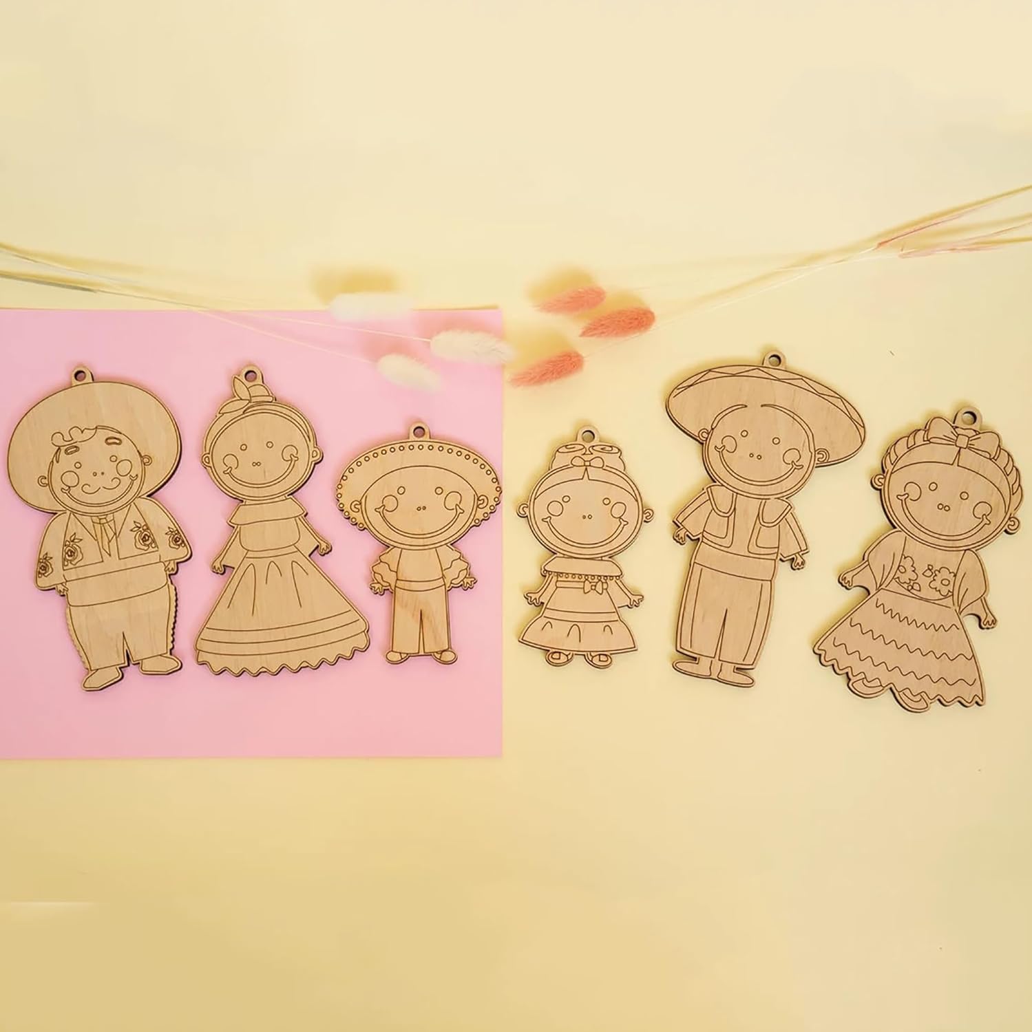 Set of wooden character cutouts on a pink and beige background