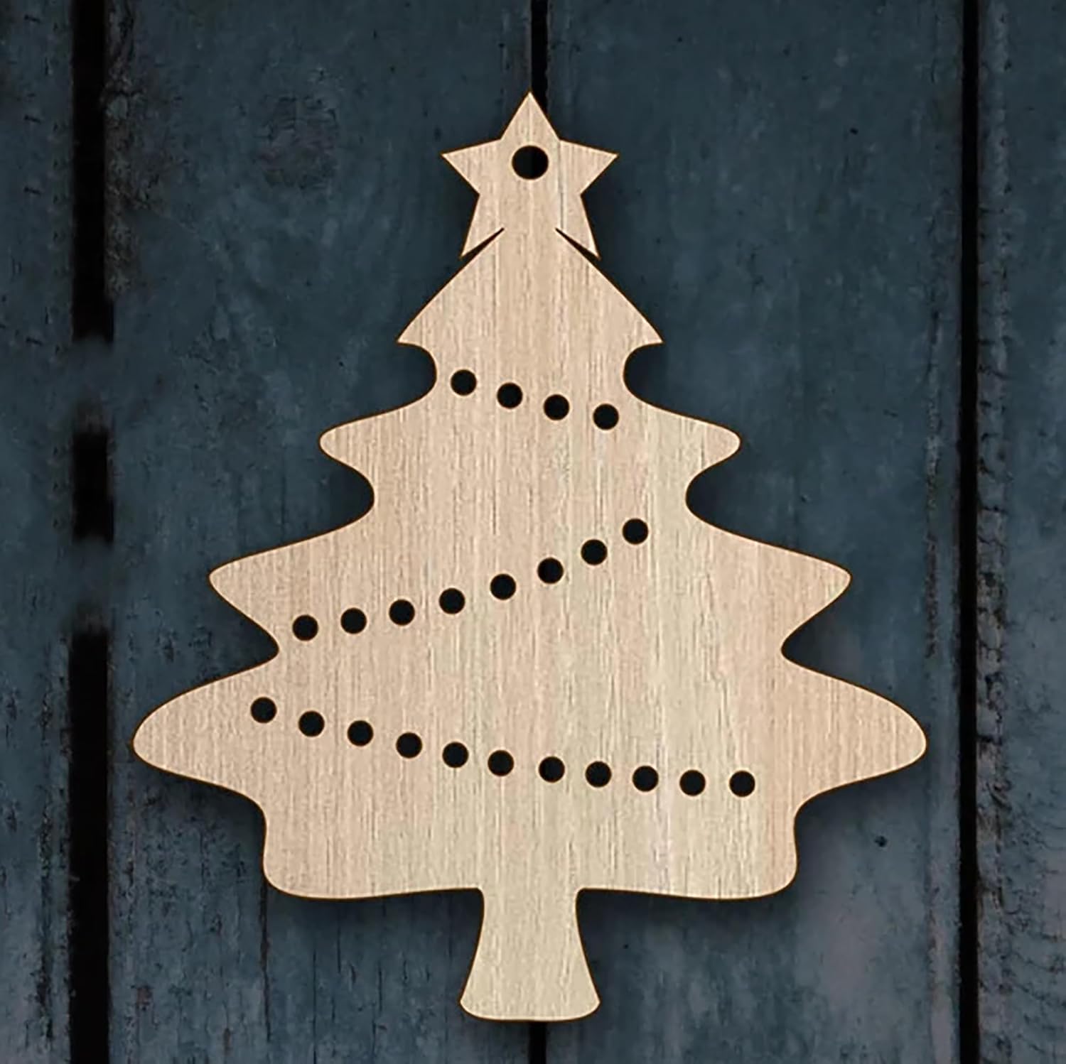 Wooden Christmas tree ornament with star on a dark wooden background