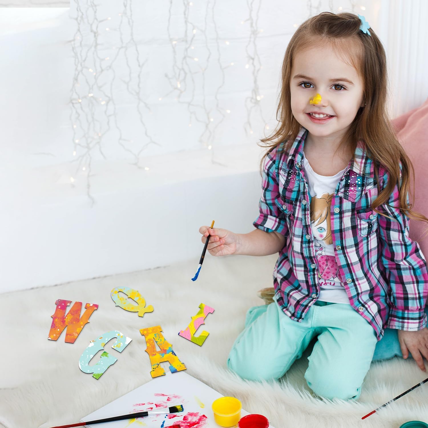 Child playing with colorful letters on a light-colored surface