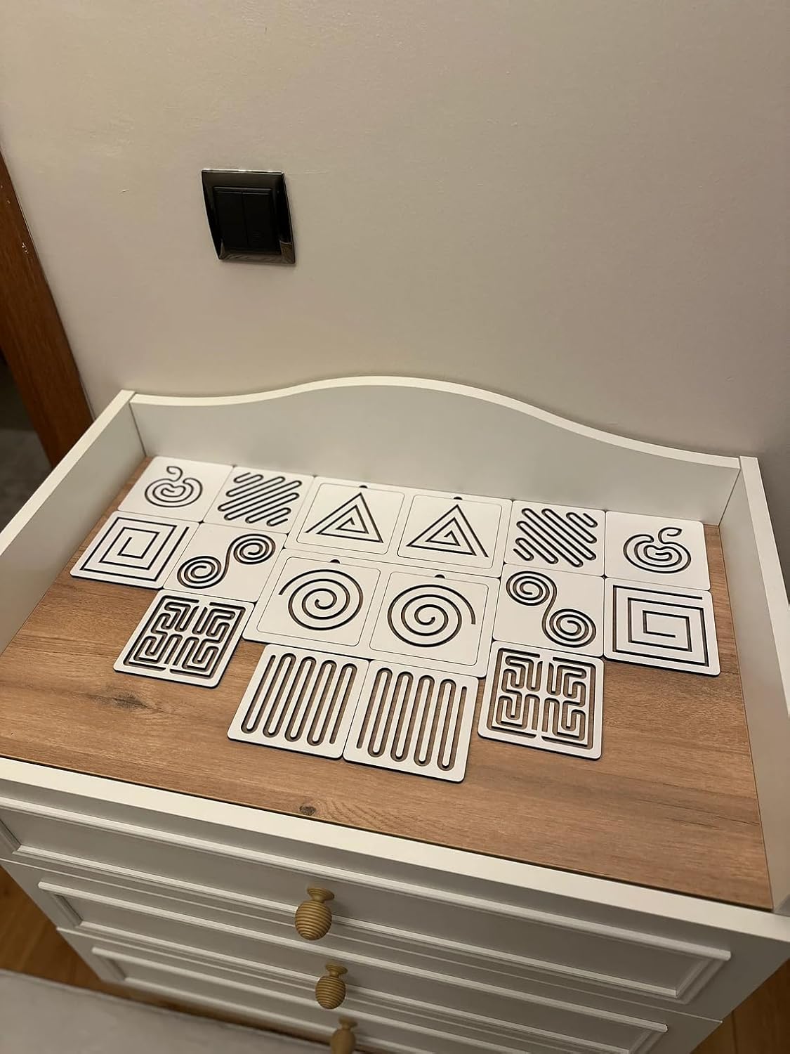 Patterned paper sheets on a wooden surface with a white frame.