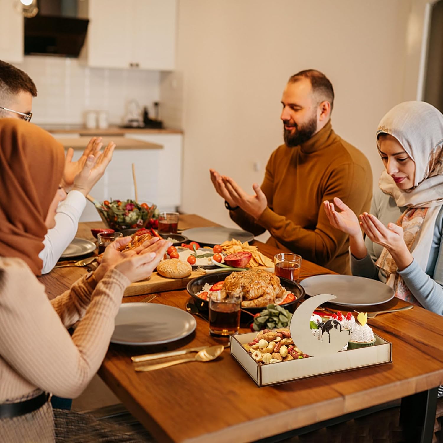 Family gathered around a dinner table for a meal, with a cake on a box in the center.