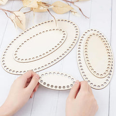 Wooden oval cutouts with holes on a light wooden surface.