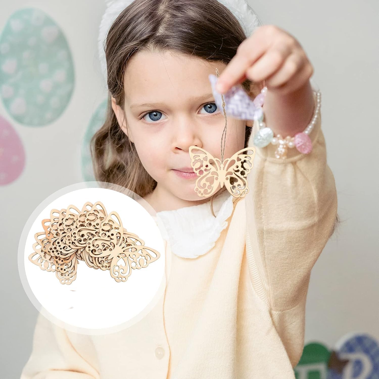 Young girl holding a decorative butterfly charm with a close-up inset of the same item.