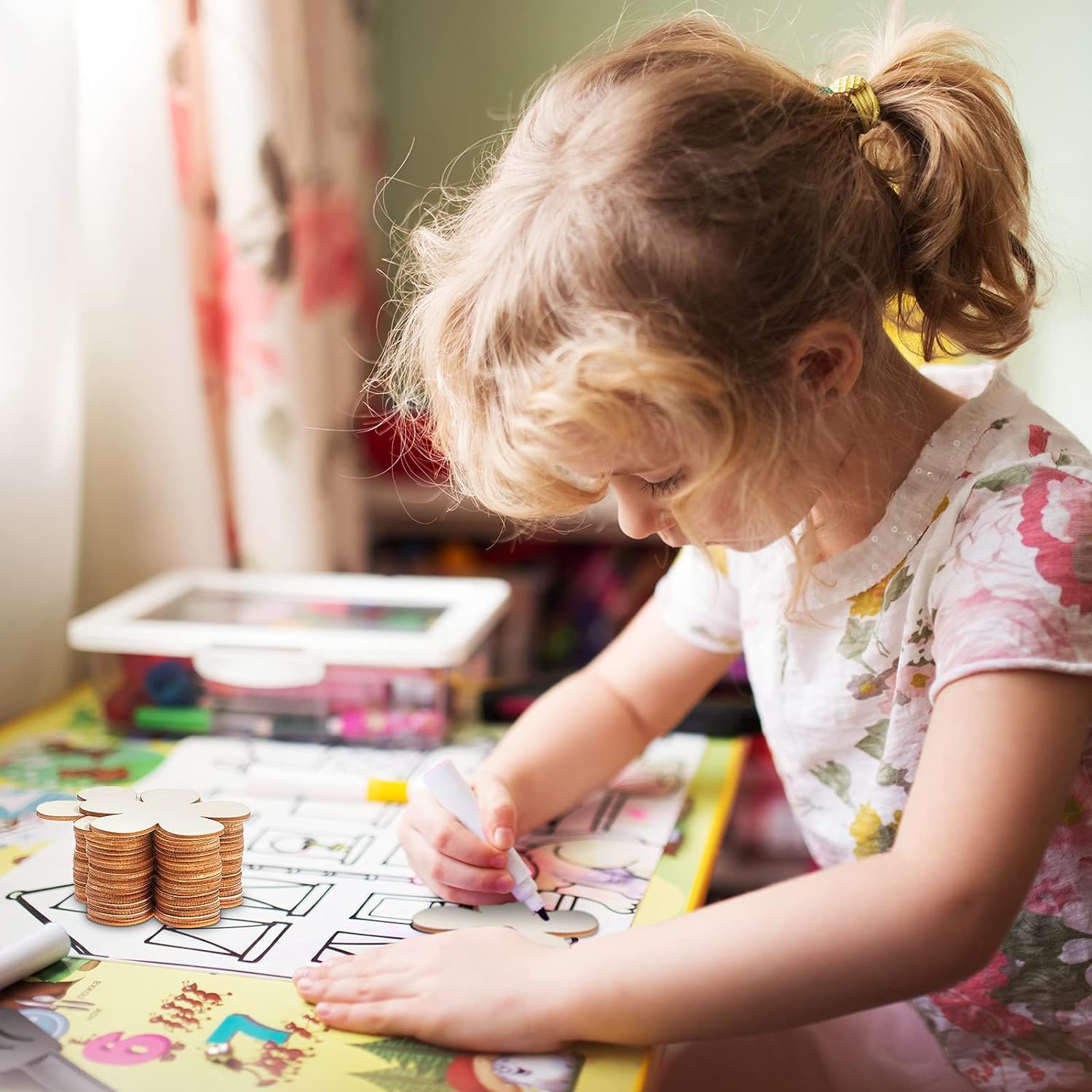 Child playing with building blocks and coloring book at a table.