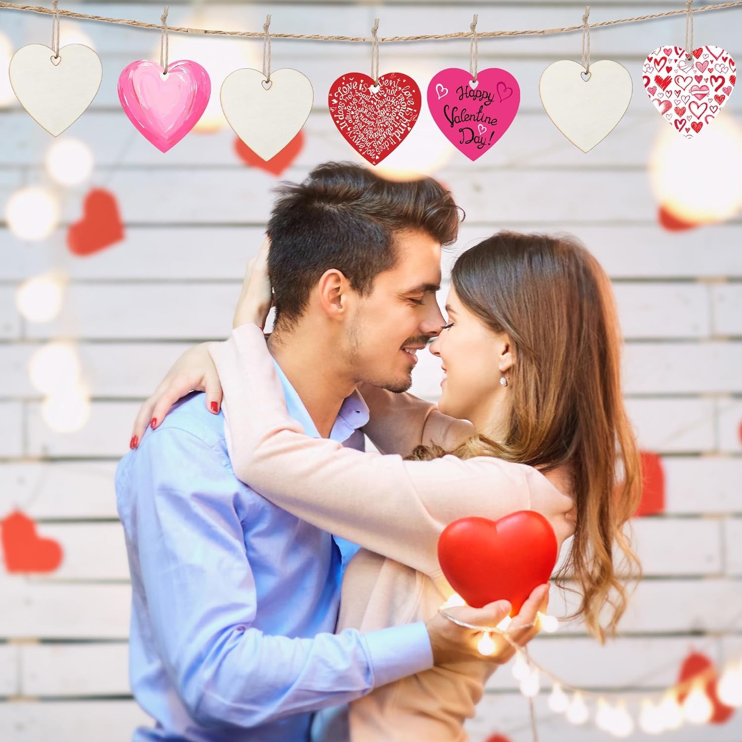 Couple embracing with heart decorations on a light wooden background