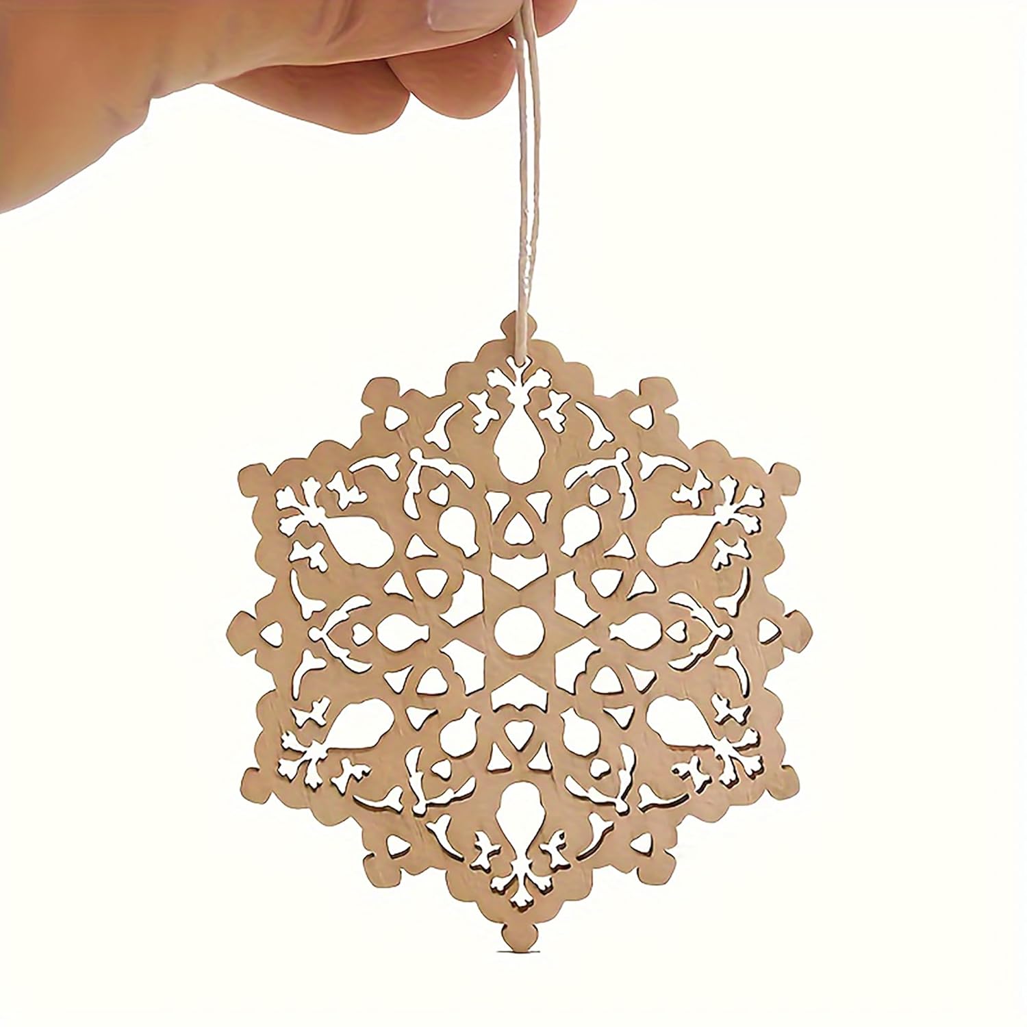 Decorative paper snowflake hanging from a string against a white background