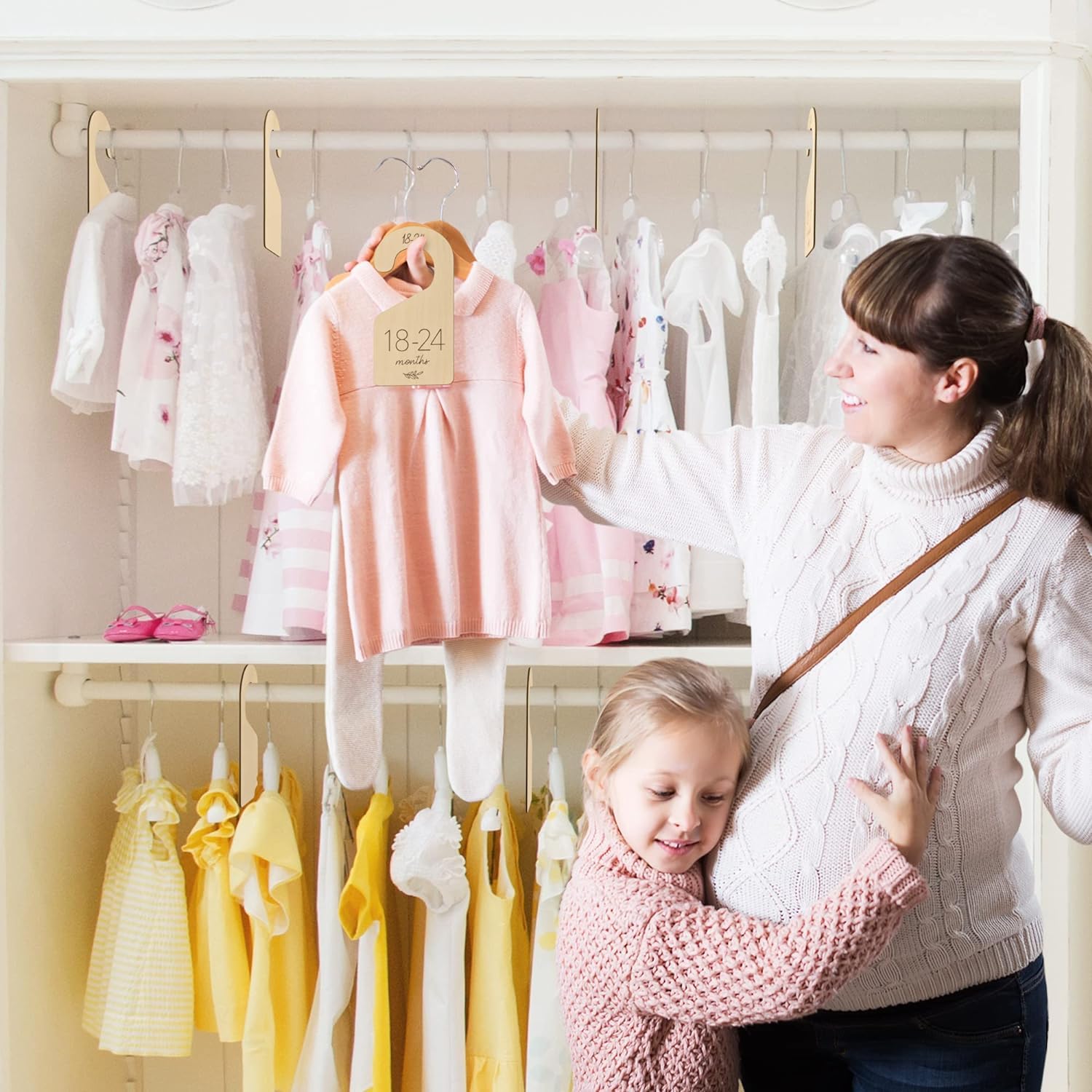 Woman and child in a clothing store with racks of children's clothes.