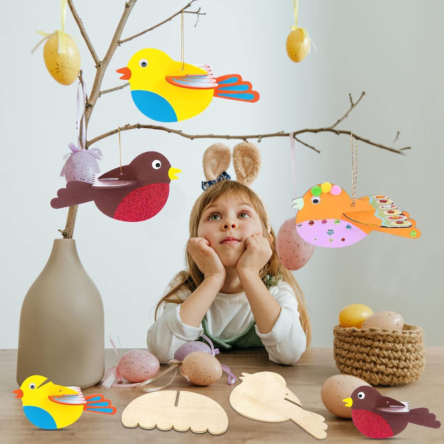 Child with Easter decorations including birds and eggs on a table.