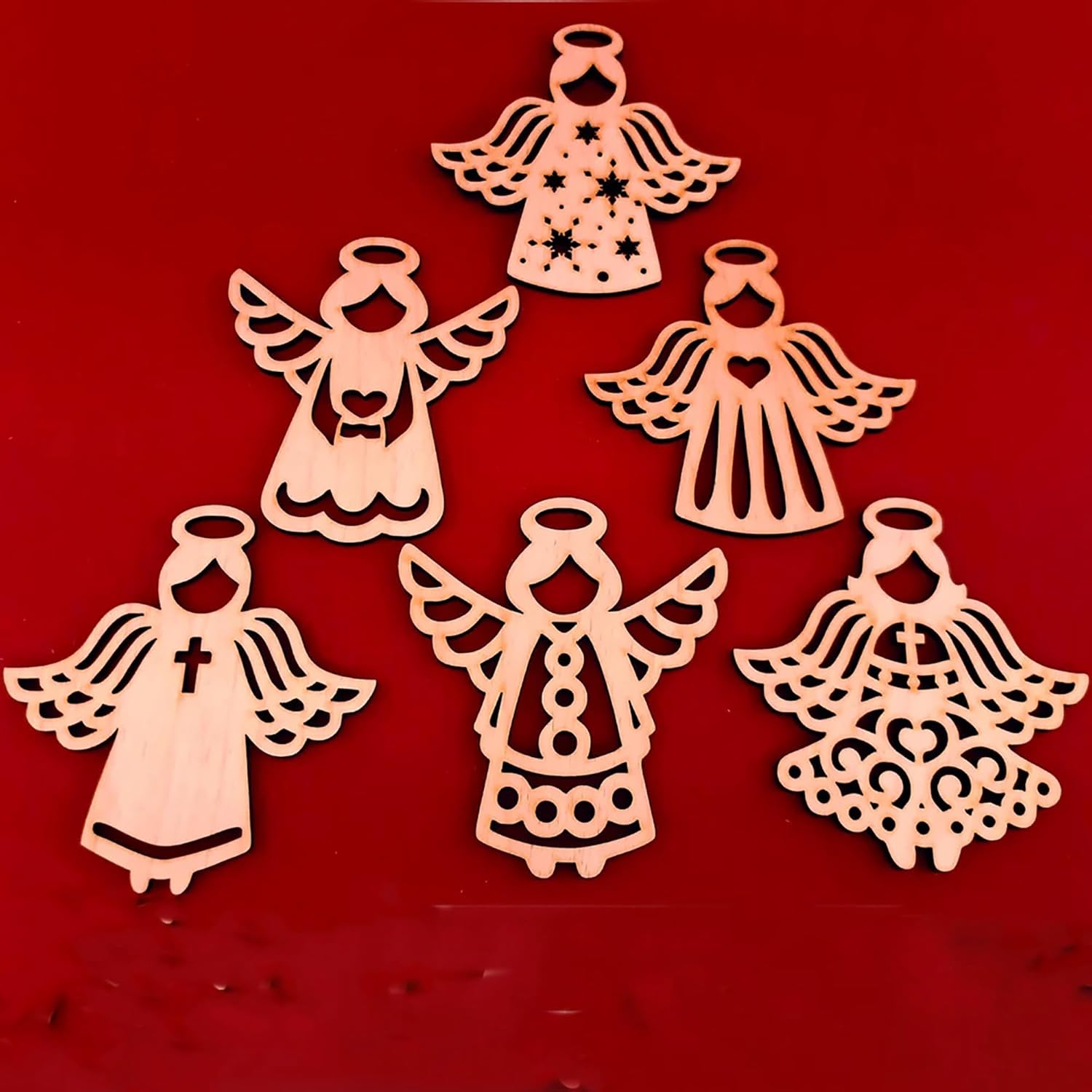 Set of six wooden angel ornaments on a red background