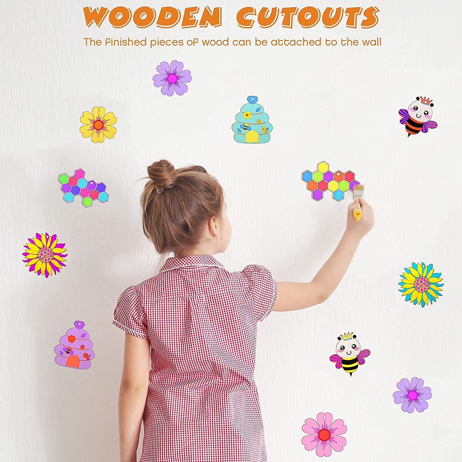 Child interacting with colorful wooden cutouts on a white wall