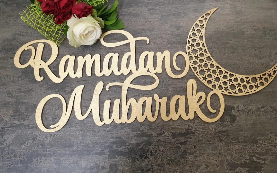 Wooden 'Ramadan Mubarak' sign with a moon design on a textured surface.