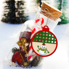 Decorative bottle with Christmas-themed items and a snowman ornament on a snowy background