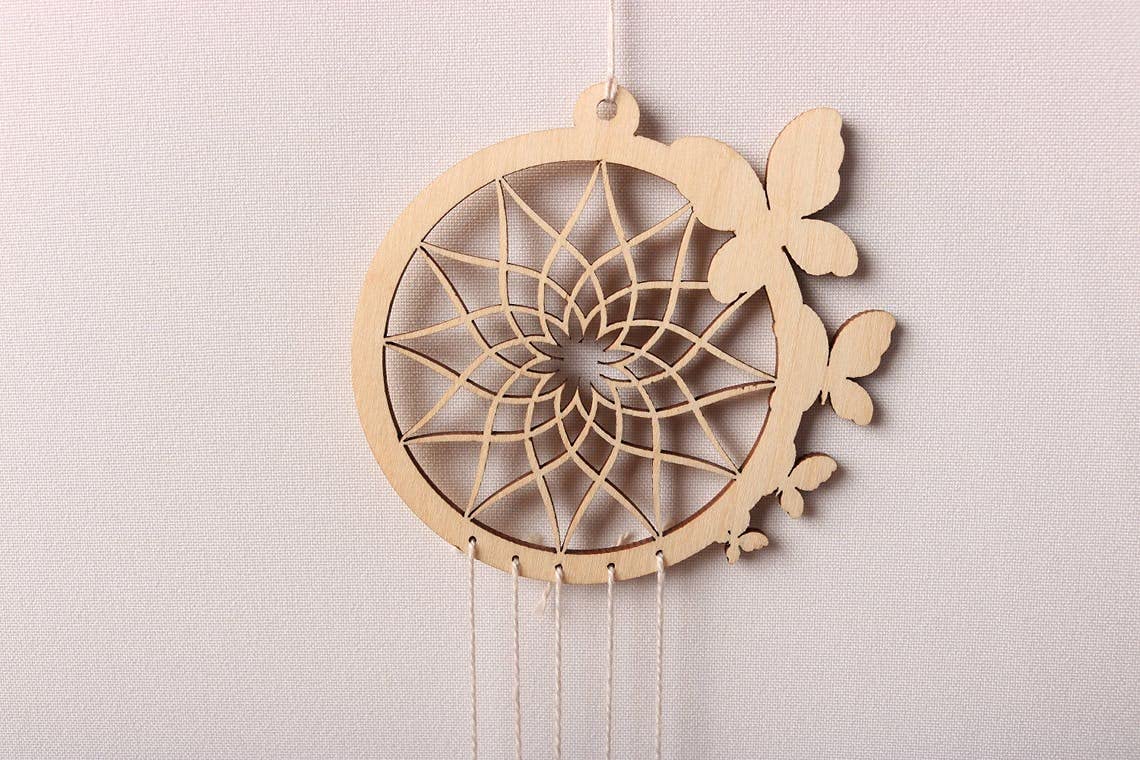Wooden dreamcatcher with feathers on a light gray background