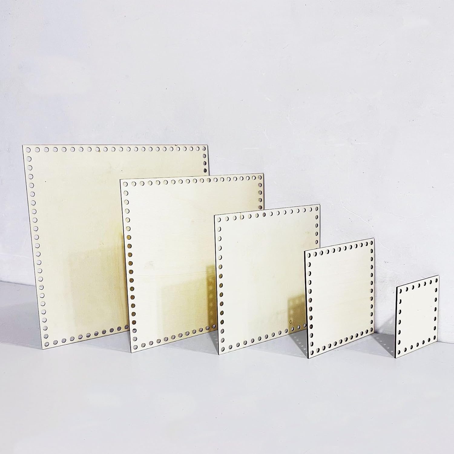 Set of square metal plates with rivet details on a white background