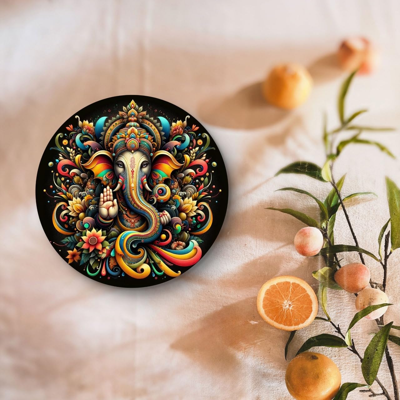 Decorative circular piece with colorful elephant design on a soft fabric background with fruits and flowers.