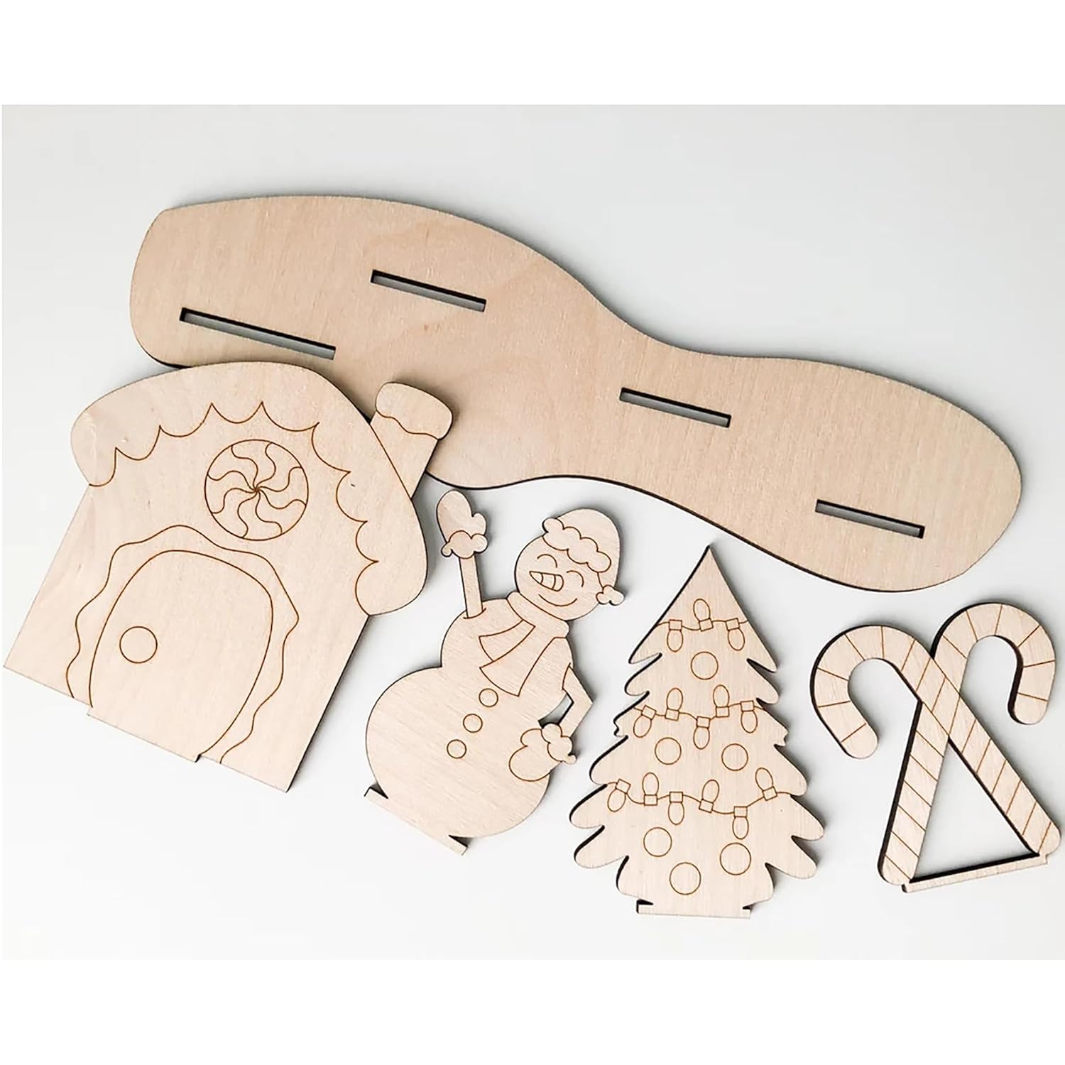 Set of wooden Christmas-themed cutouts including a gingerbread house, snowman, tree, and candy cane on a white background.