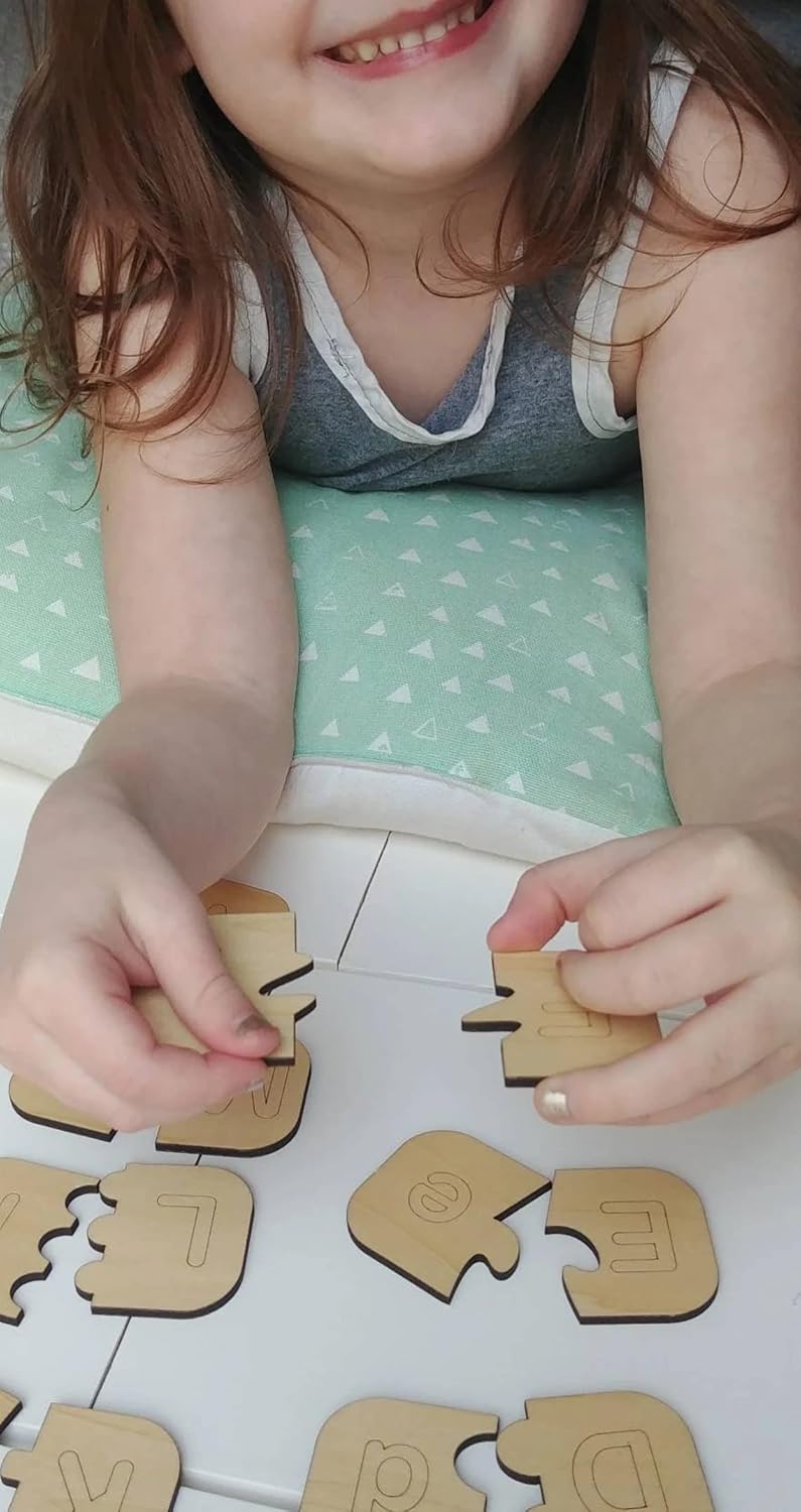 Child playing with wooden puzzle pieces on a light green mat