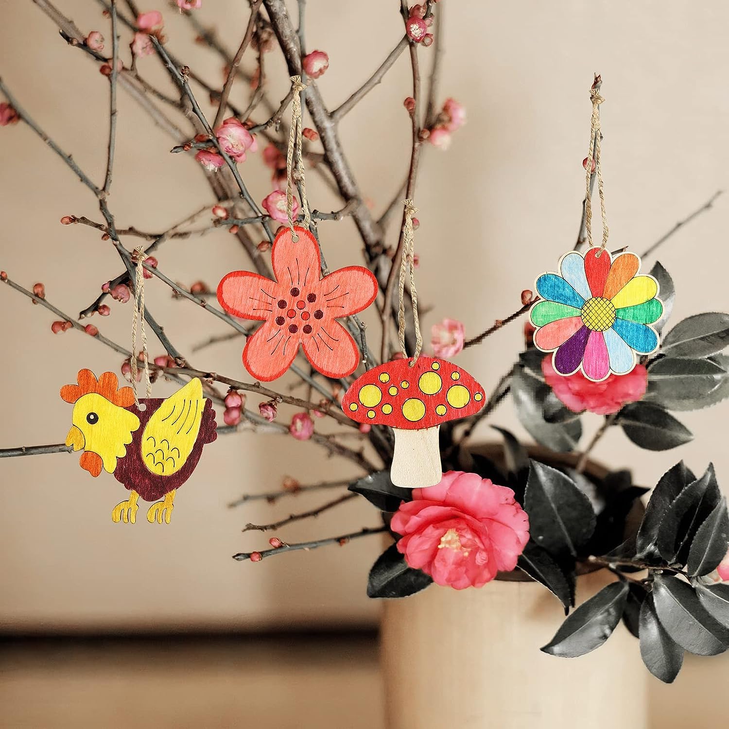 Colorful decorative ornaments including flowers and a mushroom hanging on branches.