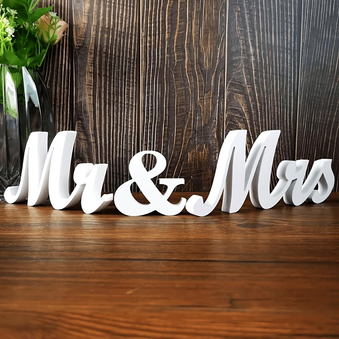 White 'Mr & Mrs' sign on a wooden surface with a wooden background