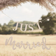 Decorative banner with 'JUST Married' text in a natural setting.
