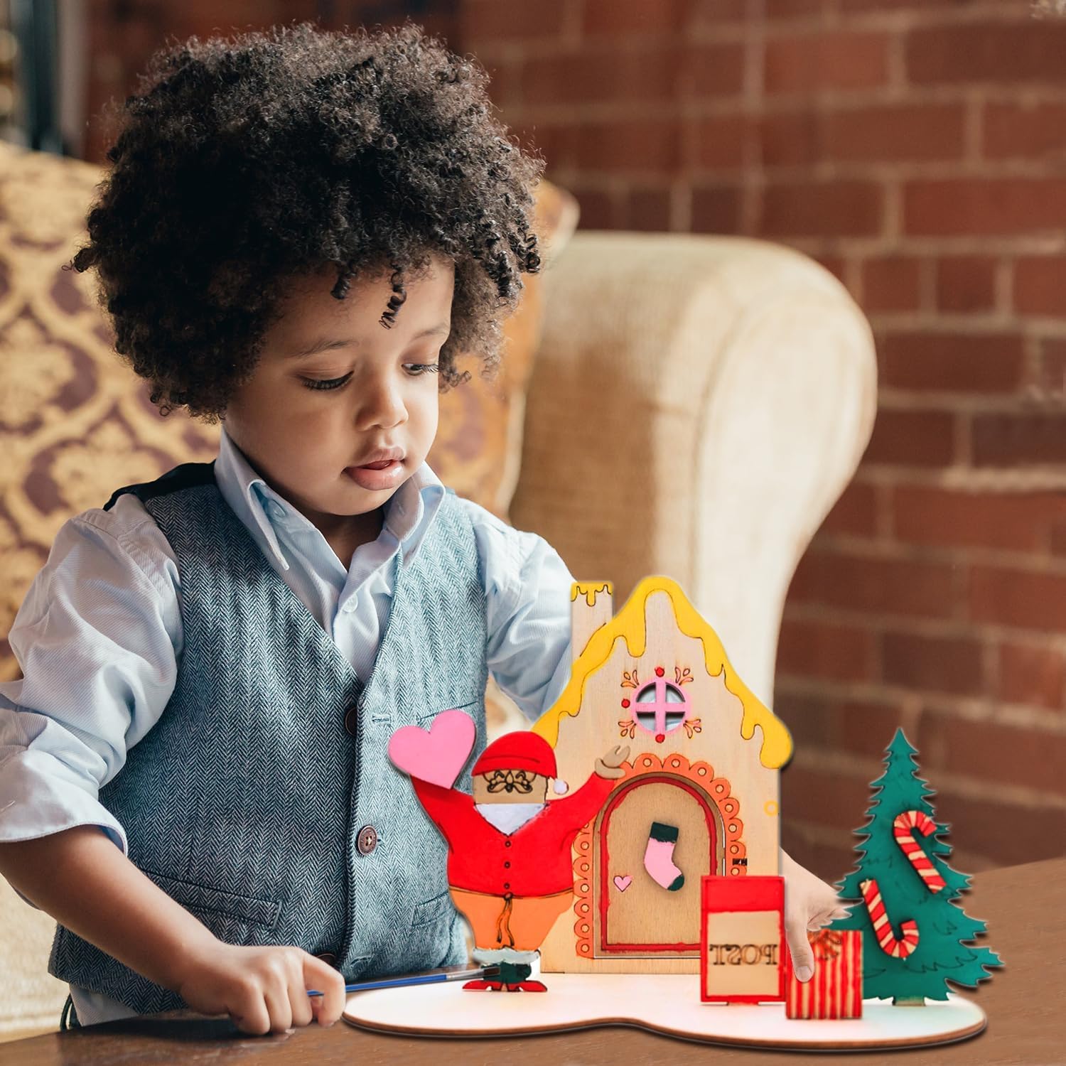 Child playing with a gingerbread house toy set on a table.
