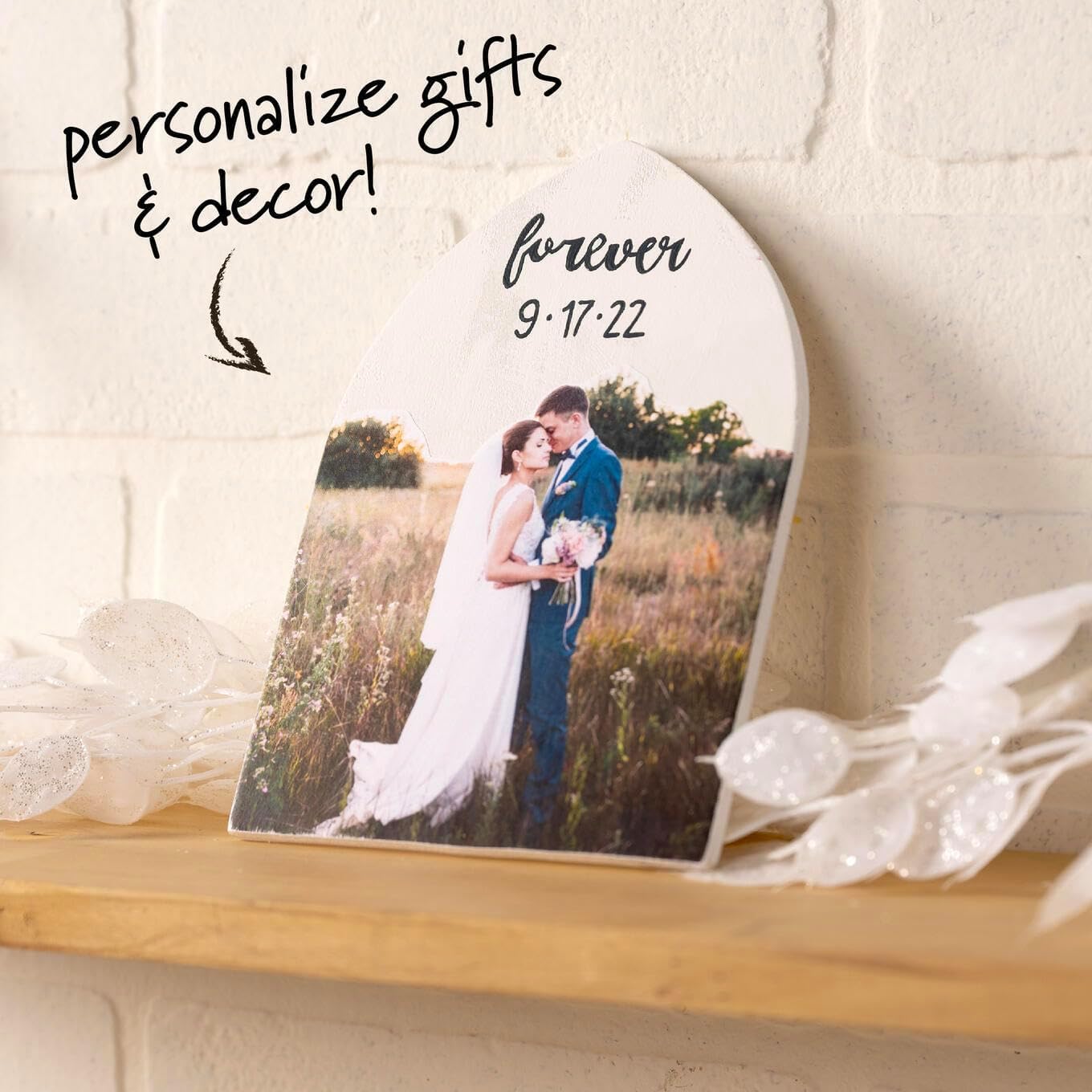 Personalized photo plaque with a couple in a field and 'forever 9:17:22' text, placed on a wooden surface.
