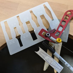 Set of metal tools with a red handle on a wooden surface