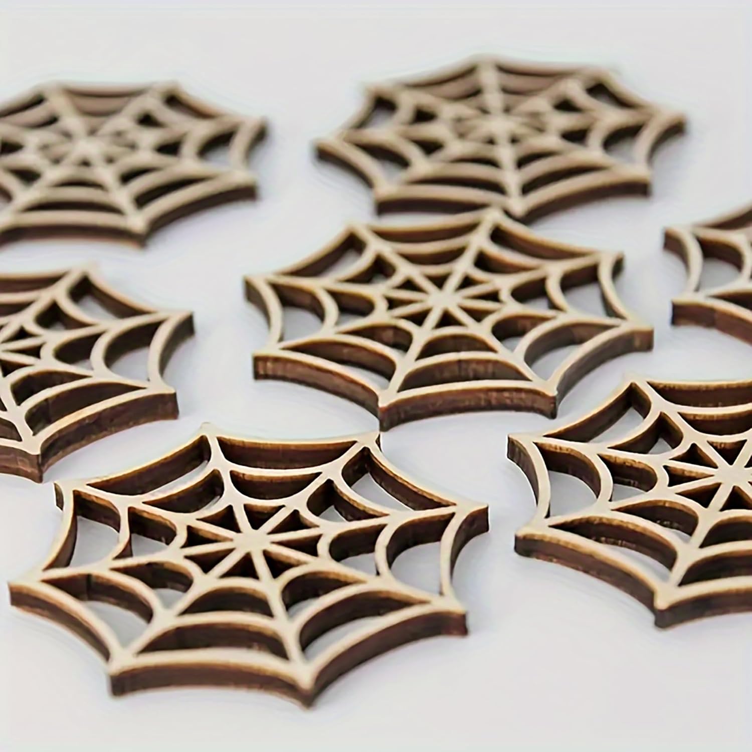Wooden spider web cutouts on a white background