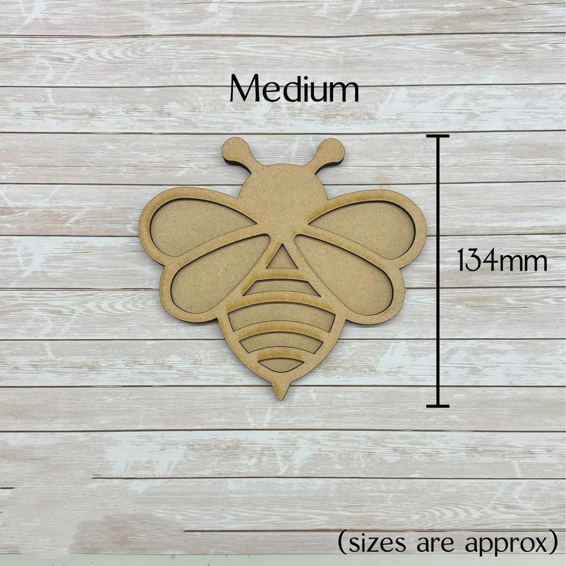 Wooden bee-shaped cutout with dimensions on a wooden background