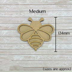 Wooden bee-shaped cutout with dimensions on a wooden background