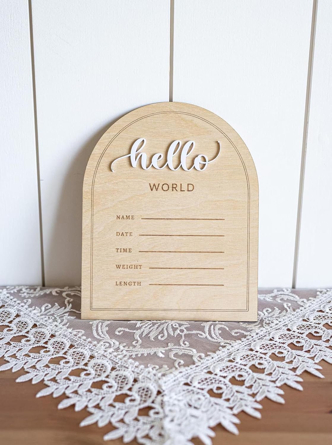 Wooden plaque with 'hello world' text on a lace tablecloth