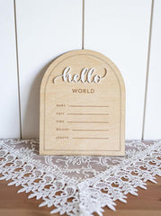 Wooden plaque with 'hello world' text on a lace tablecloth
