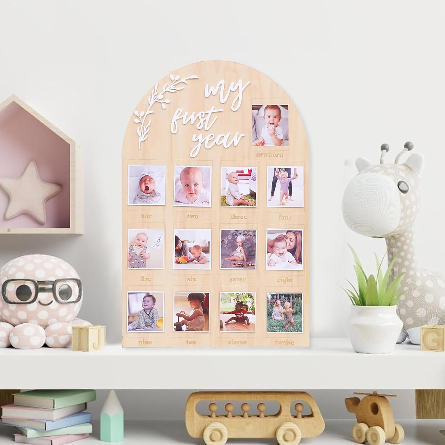 Wooden photo display with 'My First Year' text, surrounded by children's toys and decor.
