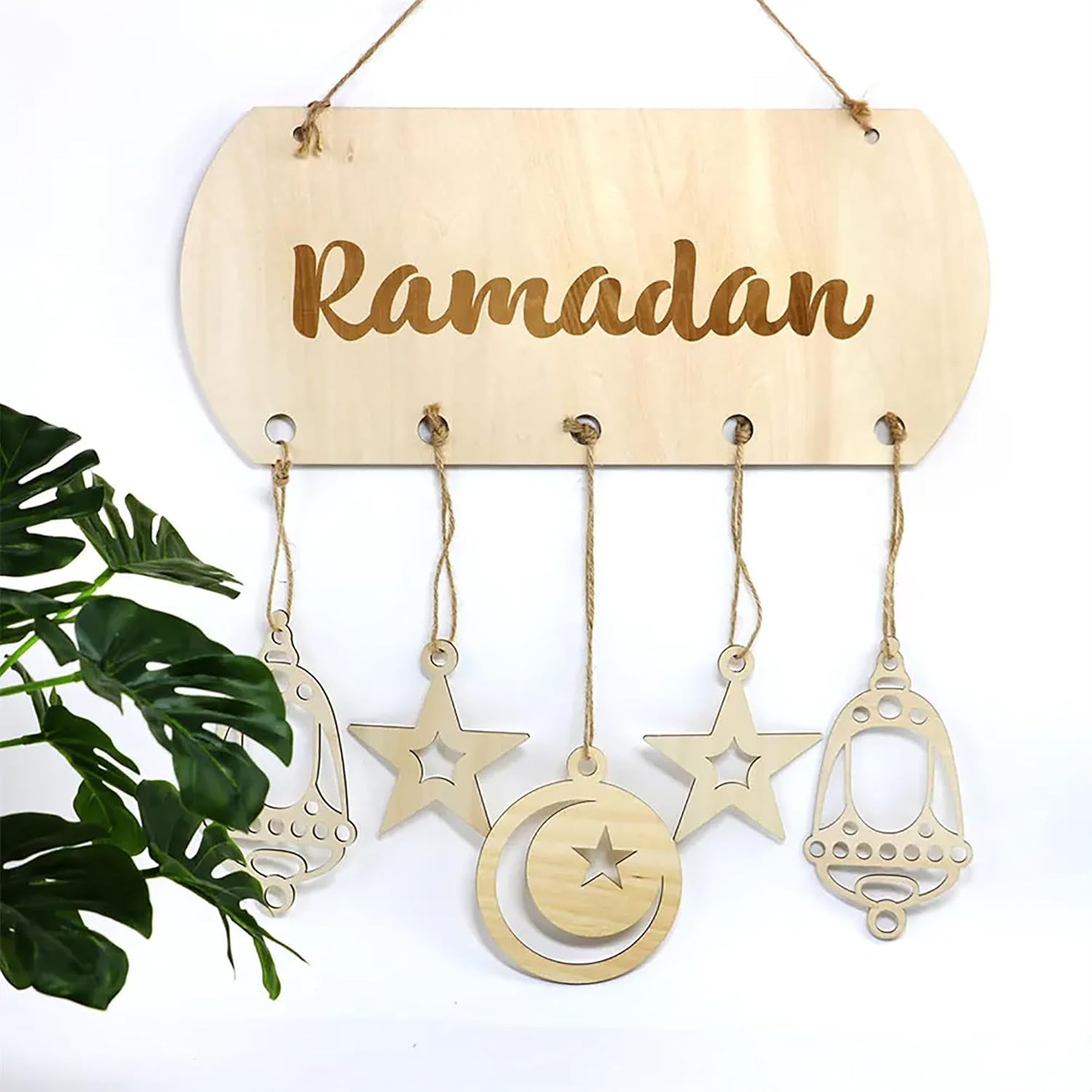 Wooden 'Ramadan' sign with hanging decorations on a white background