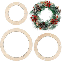 Three wooden wreath frames with a completed wreath featuring greenery, berries, and pinecones on a white background.