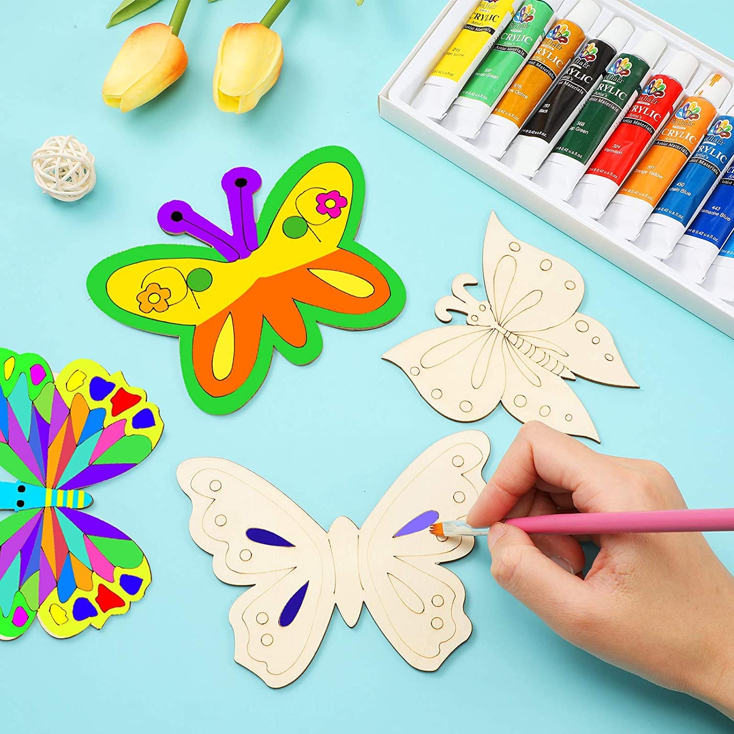 Colorful butterfly templates with paint tubes on a blue background